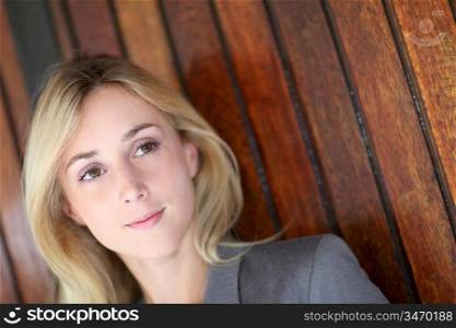 Woman leaning on wooden wall