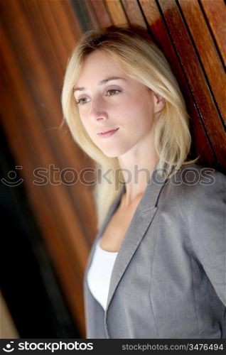 Woman leaning on wooden wall