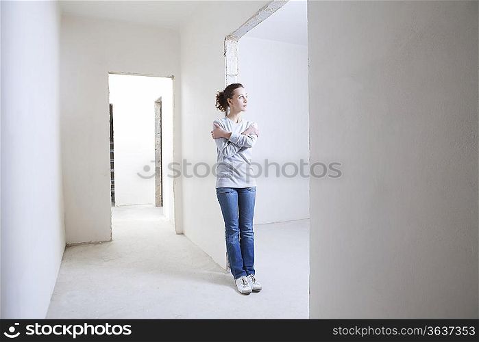 Woman leans on archway of new apartment