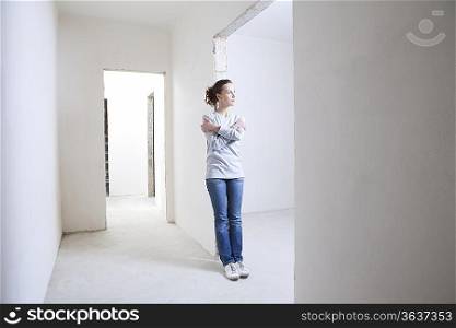 Woman leans on archway of new apartment