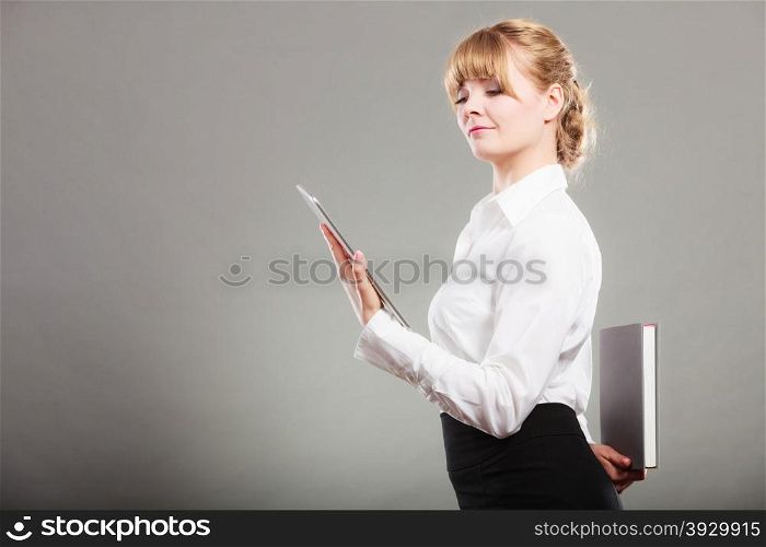 Woman learning with ebook and book. Education.. Woman learning with ebook reader holding book behind back. Choice between modern educational technology and traditional way method. Girl hold digital tablet pc and textbook. Contemporary education.