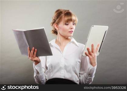 Woman learning with ebook and book. Education.. Woman learning with ebook reader and book. Choice between modern educational technology and traditional way method. Girl holding digital tablet pc and textbook. Contemporary education.