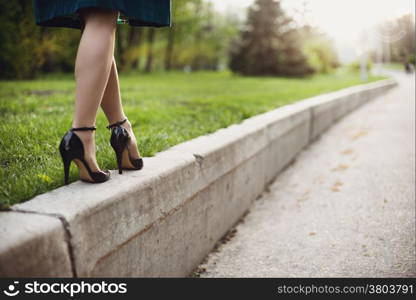 Woman legs and high heels in the park