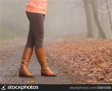 Woman legs in brown boots. Female in autumn park forest. Fall winter fashion.. Woman legs in brown boots. Fall fashion