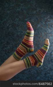 Woman legs in wool knitted socks. Woman legs in wool knitted socks on a grey background