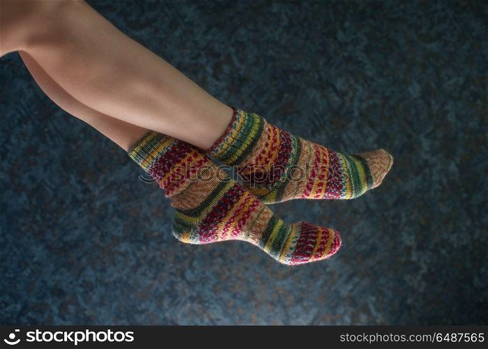 Woman legs in wool knitted socks. Woman legs in wool knitted socks on a grey background