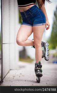Woman legs wearing roller skates riding in town. Female being sporty having fun during summer time.. Woman riding roller skates