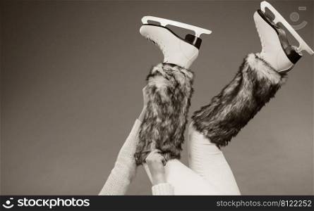 Woman legs wearing skates fur warm socks. Girl getting ready for ice skating. Winter sport activity. Studio shot b w photo. Woman legs wearing ice skates fur socks, skating 