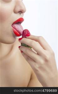 Woman licking a strawberry