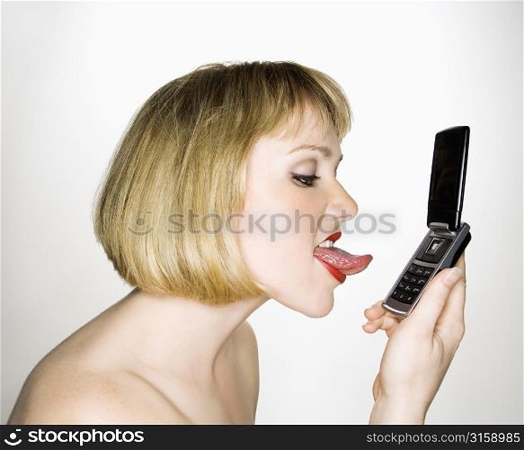 Woman licking mobile phone