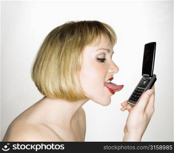 Woman licking mobile phone