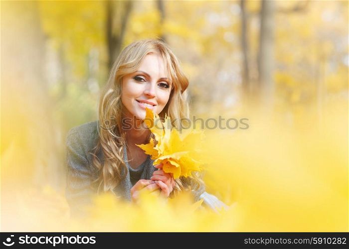 Woman lies in maple leaves . Young woman lies in maple leaves at autumn park