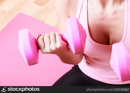 Woman lifting two dumbbells. Young girl exercising in gym. Health workout fitness concept. . Woman lifting two dumbbells.