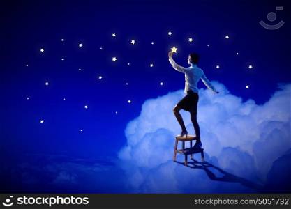Woman lighting stars. Image of young woman lighting stars in night sky