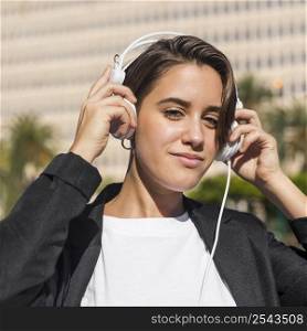 woman listening music headphones outdoors