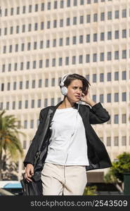 woman listening music headphones outside