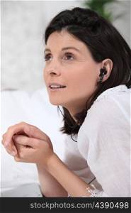 Woman listening to headphones in bed