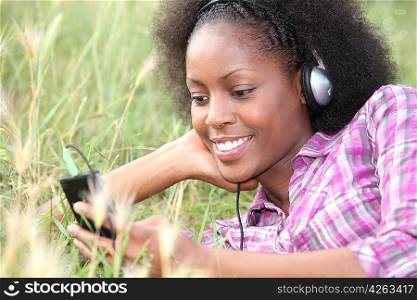 Woman listening to music in a field of grass