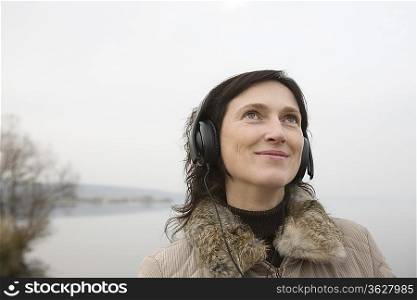 Woman listening to music near lake
