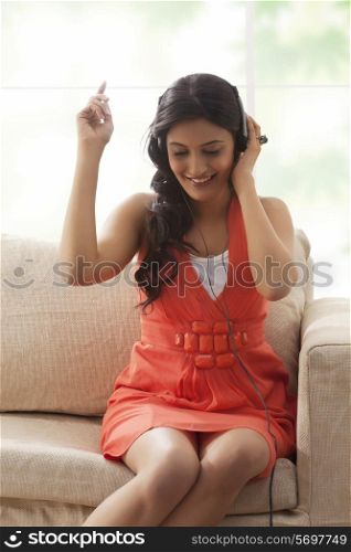 Woman listening to music on a sofa