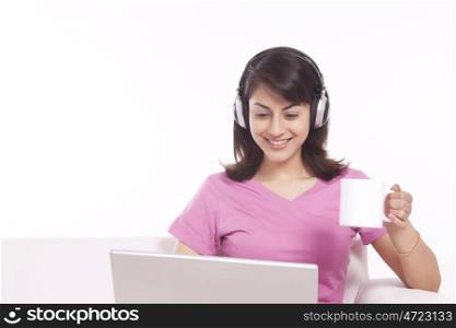 Woman listening to music while having tea