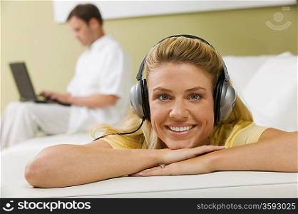 Woman Listening to Music While Husband Works