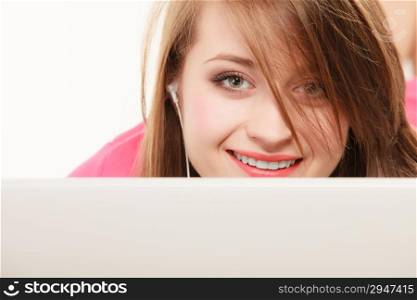 Woman listening to music with headphones and using computer laptop. Student girl learning language with new technology.