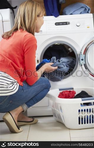 Woman Loading Clothes Into Washing Machine
