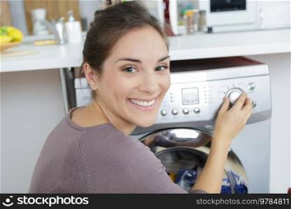 woman loading dirty clothes in washing machine