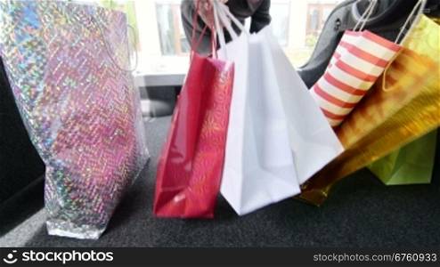 Woman loading her car trunk with shopping bags, inside view