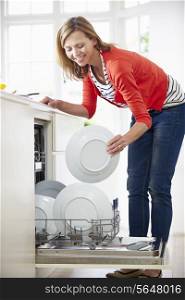 Woman Loading Plates Into Dishwasher