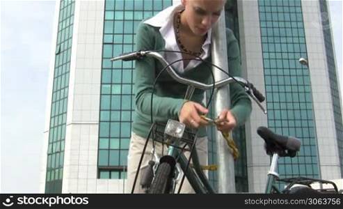 woman locking padlock to her bike. 30 fps