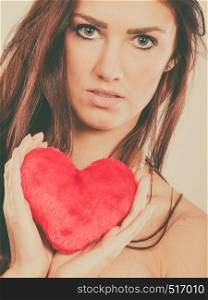Woman long hair young female holding red heart love symbol studio shot on bright. Valentines day happiness concept. Filtered photo. Woman holds red heart love symbol