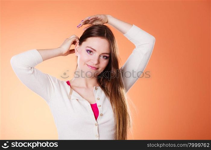 Woman long straight hair colorful makeup portrait studio shot on orange background