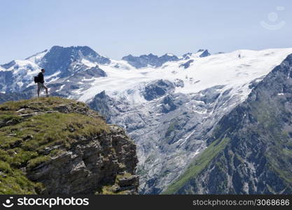 Woman looking a La Meije Glacier from Emparis plateau, Oisans, Alps, France. Woman looking a La Meije Glacier from Emparis plateau