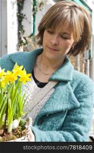 Woman looking at a basket with daffodils she intends to buy