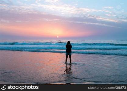 Woman looking at amazing sunset at the westcoast in Portugal