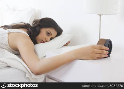 Woman looking at bedside clock