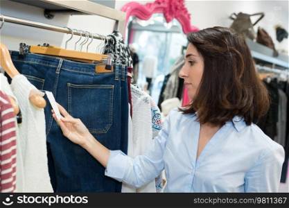 woman looking at clothing price tag