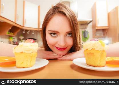 Woman looking at delicious cake with sweet cream and fruits on top. Appetite and gluttony concept.. Woman looking at delicious sweet cake. Gluttony.