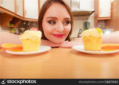Woman looking at delicious cake with sweet cream and fruits on top. Appetite and gluttony concept.. Woman looking at delicious sweet cake. Gluttony.