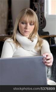 Woman looking at her laptop at home