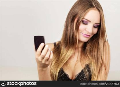 Woman looking at herself in mirror. Attractive pretty gorgeous girl long haired with makeup . Woman attractive girl looking in mirror