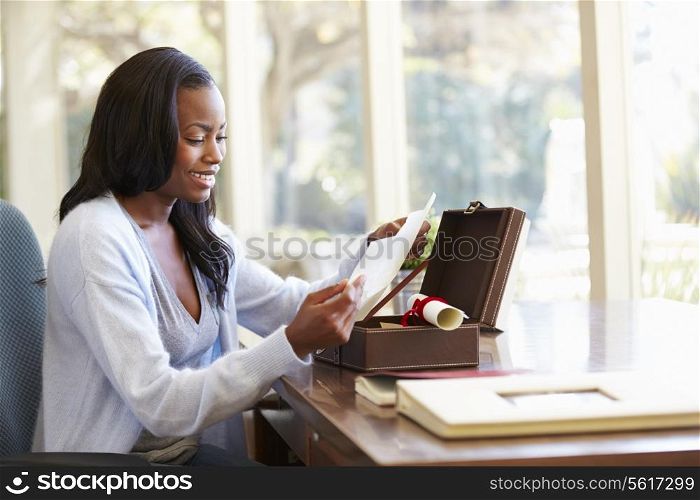 Woman Looking At Letter In Keepsake Box On Desk