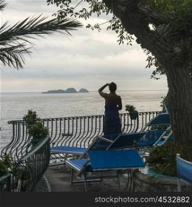 Woman looking at sea from a resort, Positano, Amalfi Coast, Salerno, Campania, Italy