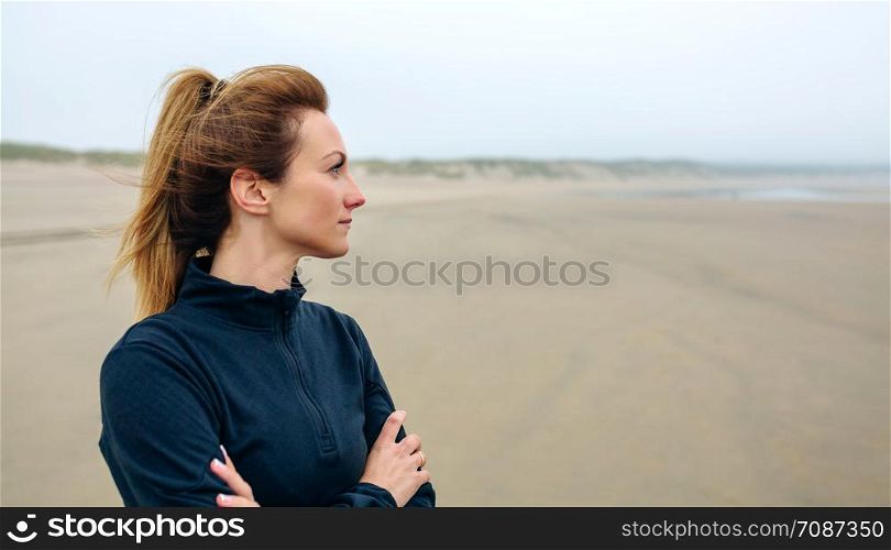 Woman looking at sea on the beach in autumn. Woman looking at sea