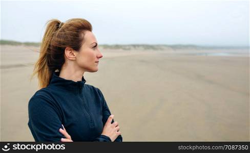 Woman looking at sea on the beach in autumn. Woman looking at sea