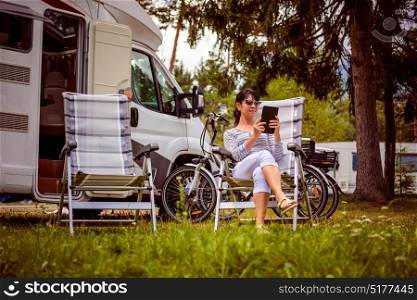 Woman looking at the laptop near the camping . Caravan car Vacation. Family vacation travel, holiday trip in motorhome. Wi-fi connection information communication technology.