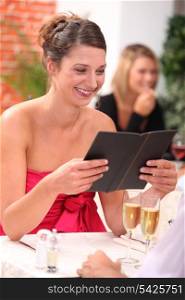 woman looking at the menu at a restaurant