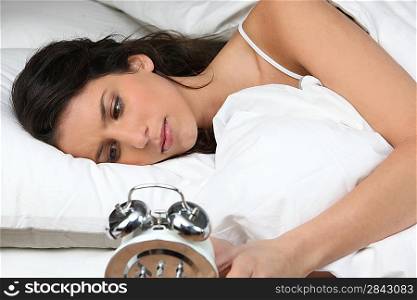 Woman looking her alarm clock
